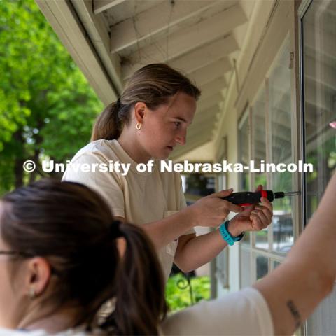 Members of Tri Delta remove and replace window guards to clean windows during the Big Event. May 4, 2024. Photo by Kirk Rangel for University Communication.